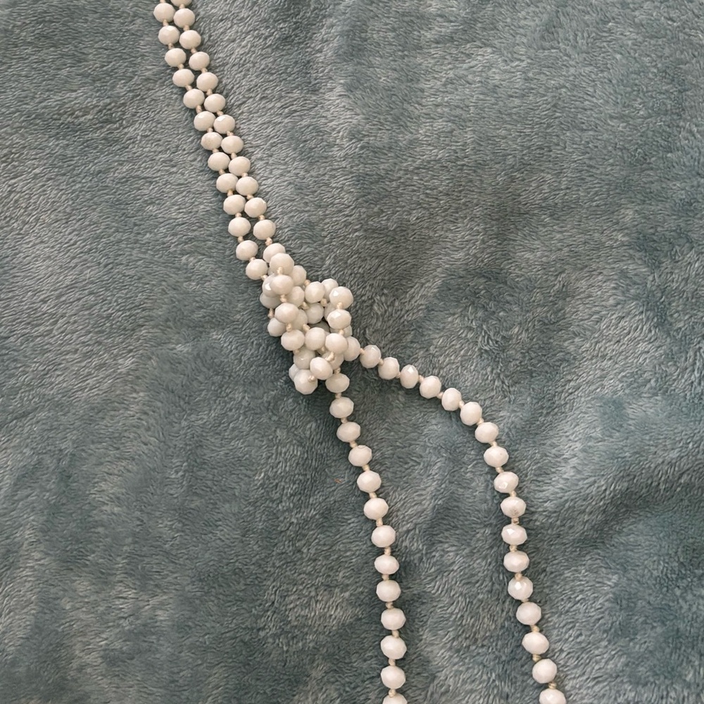 Long white beaded necklace.